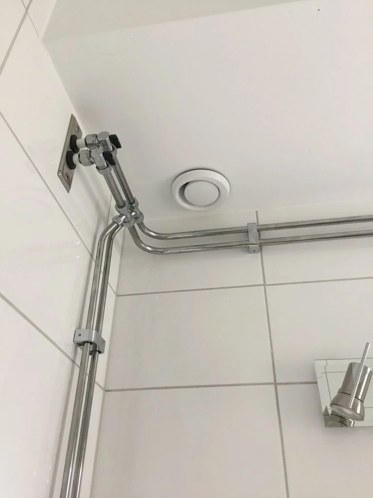 Frånluftsdon i taket i en dusch med vitt kakel, villa i Sollentuna