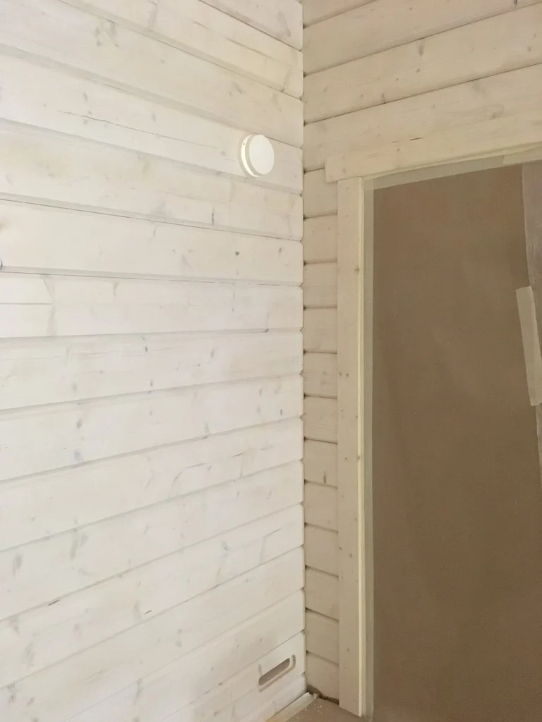 Friskluftsventil Fresh Thermo på en vitlaserad panelvägg i ett rum